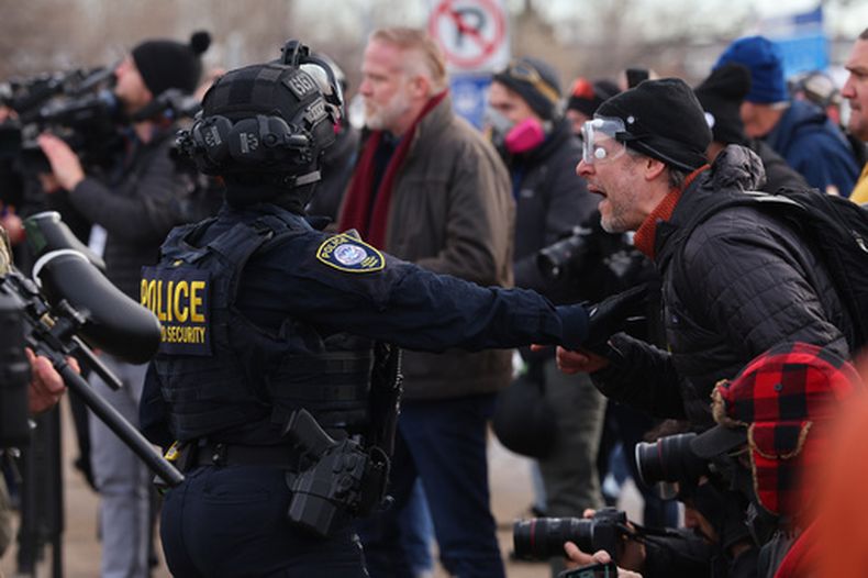 Manifestantes se enfrentan a las fuerzas del orden fuera del edificio federal Bishop Henry Whipple en Minneapolis, el viernes 9 de enero de 2026.(AP Foto/Adam Bettcher)