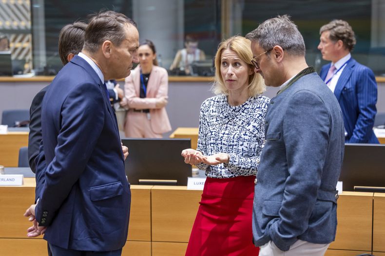 La jefa de política exterior de la Unión Europea, Kaja Kallas, en el centro, habla con el ministro polaco de Exteriores, Radoslaw Sikorski, a la izquierda, y el ministro de Exteriores de Luxemurgo, Xavier Bettel, a la derecha, durante la reunión de ministros de Exteriores en la sede del Consejo Europeo, en Bruselas, el martes 15 de julio de 2025. (AP Foto/Geert Vanden Wijngaert)