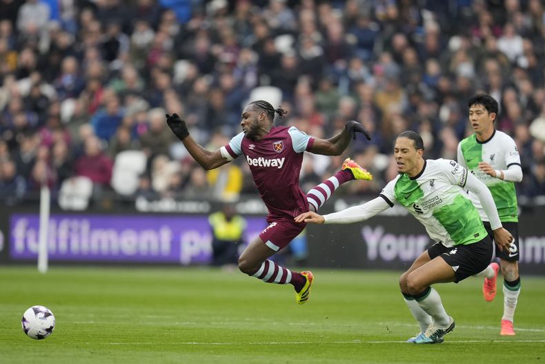 Michail Antonio de West Ham cae al pugnar el balón con Virgil van Dijk de Liverpool en el partido de la Liga Premier, el sábado 27 de abril de 2024. (AP Foto/Kin Cheung)