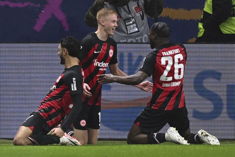 Hugo Larsson del Eintracht Frankfurt celebra con sus compañeros Omar Marmoush y Eric Junior Dina Ebimbe tras anotar el tercer gol de su equipo en el encuentro ante el Bayern Munich en la Bundesliga en el Deutsche Bank Park el sábado 9 de diciembre del 2023. (Arne Dedert/dpa via AP)