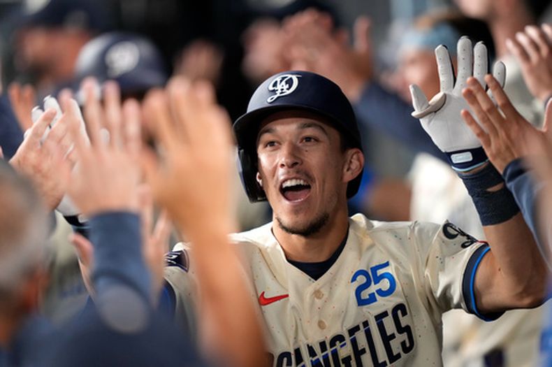 Tommy Edman, de los Dodgers de Los Ángeles, festeja en el dugout tras batear un jonrón de tres carreras ante los Nacionales de Washington el sábado 5 de septiembre de 2026 (AP Foto/Mark J. Terrill)