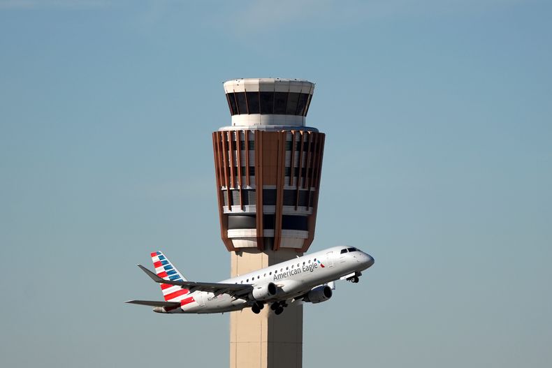 Un avión American Eagle de American Airlines pasa por la torre de control de tráfico aéreo en el Aeropuerto Internacional Phoenix Sky Harbor, el sábado 8 de noviembre de 2025, en Phoenix. (AP Foto/Ross D. Franklin)