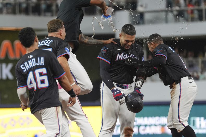 El dominicano Agustín Ramírez y Xavier Edwards de los Marlins de Miami son bañados tras la victoria ante los Yankees de Nueva York el viernes primero de agosto del 2025. (AP Foto/Rebecca Blackwell)