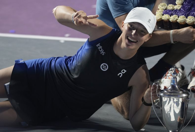 ARCHIVO - Iga Swiatek posa con el trofeo de campeona tras derrotar a Jessica Pegula en el partido por el título de las Finales de la WTA, el 6 de noviembre de 2023 en Cancún, México. (AP Foto/Fernando Llano)