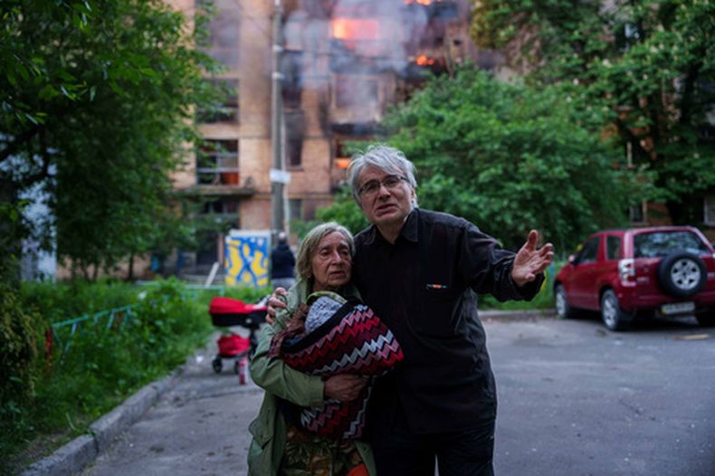 Iryna e Ihor reaccionan mientras miran a su casa destruida tras un ataque ruso en Kiev, Ucrania, el domingo 24 de mayo de 2026. (AP Foto/Evgeniy Maloletka)