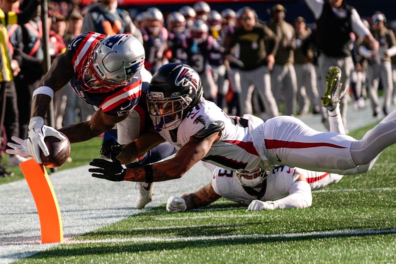 Stefon Diggs (8), wide receiver de los Patriots de Nueva Inglaterra, anota un touchdown contra Mike Hughes (21), cornerback de los Falcons de Atlanta, durante la primera mitad de un juego de fútbol americano de la NFL, el domingo 2 de noviembre de 2025, en Foxborough, Massachusetts. (AP Photo/Charles Krupa)