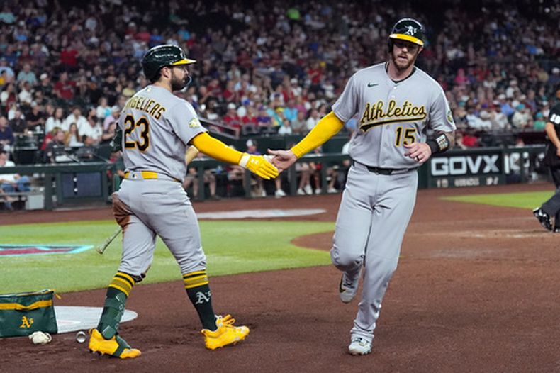 Jonah Heim (15), de los Atléticos, celebra su carrera anotada contra los Diamondbacks de Arizona junto con Shea Langeliers (23), de los Atléticos, durante la tercera entrada de un partido de béisbol, el miércoles 22 de julio de 2026, en Phoenix. (Foto AP/Ross D. Franklin)