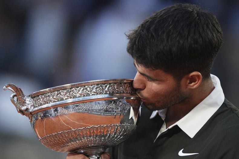 Carlos Alcaraz besa el trofeo de campeón del Abierto de Francia, el domingo de 8 junio de 2025, en París (AP Foto/Lindsey Wasson)
