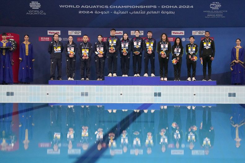 Los equipos del Reino Unido, oro; México, plata; y Australia, bronce posan tras la ceremonia de medallas en las pruebas mixtas de 3 y 10 metros del Mundial de Natación en Doha, Qatar el viernes 2 de febrero del 2024. (AP Foto/Hassan Ammar)