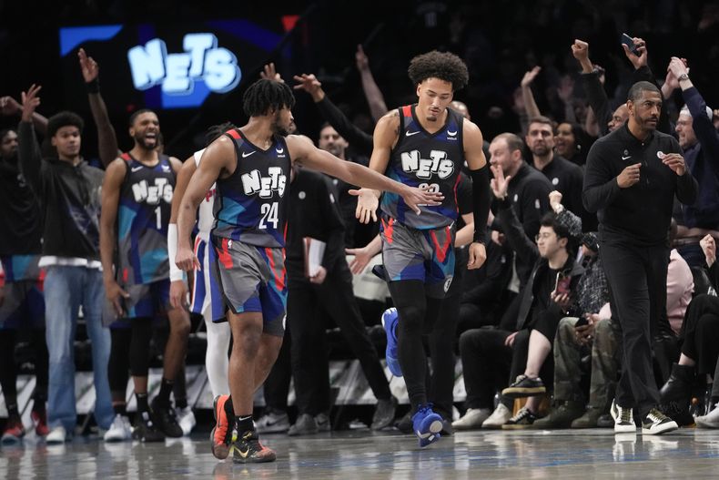 El armador de los Nets de Brooklyn Cam Thomas (24) y el escolta Jalen Wilson (22) reaccionan durante la segunda mitad del juego de baloncesto ante los Pistons de Detroit, el sábado 6 de abril de 2024, en Nueva York. (AP Foto/Mary Altaffer)