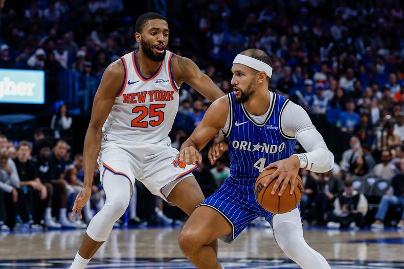Jalen Suggs, del Magic de Orlando, trata de avanzar frente a Mikal Bridges, de los Knicks de Nueva York, durante el partido del sábado 22 de noviembre de 2025 (AP Foto/Kevin Kolczynski)