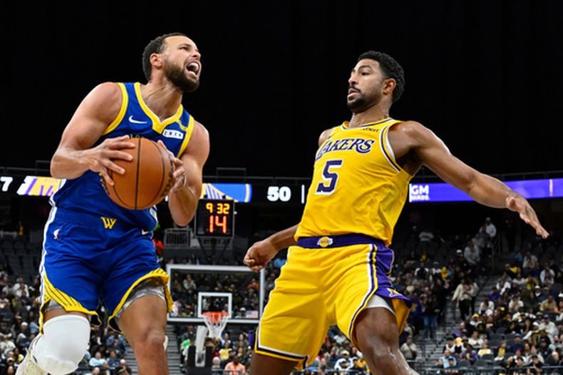 Stephen Curry, de los Warriors de Golden State, controla el balón frente a Quentin Grimes, de los Lakers de Los Ángeles, en un partido de pretemporada realizado el martes 13 de octubre de 2026 en Las Vegas (AP Foto/David Becker)