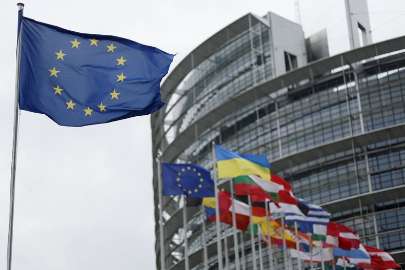 La bandera europea (izq) en la sede del Parlamento Europeo en Estrasburgo, Francia, el 18 de abril de 2023. (Foto AP/Jean-Francois Badias)