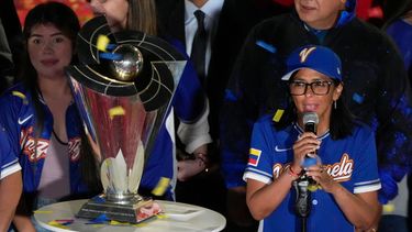 La presidenta interina de Venezuela, Delcy Rodríguez, a la derecha, a un costado del trofeo del Clásico Mundial de Béisbol un día después de que el equipo de Venezuela derrotó en la final a Estados Unidos, el miércoles 18 de marzo de 2026, en el Palacio Presidencial de Miraflores, en Caracas. (AP Foto/Ariana Cubillos)