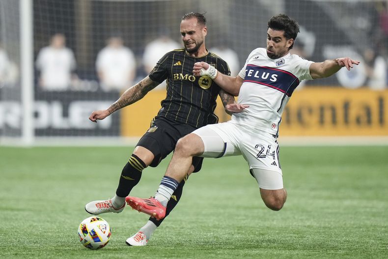 Maxime Chanot, de Los Angeles FC, a la izquierda, y Brian White, de los Whitecaps de Vancouver, a la derecha, compiten por el balón durante la primera mitad del Juego 2 de la primera ronda de los playoffs de fútbol de la Copa MLS en Vancouver, Columbia Británica, el domingo 3 de noviembre de 2024. (Darryl Dyck/The Canadian Press vía AP)