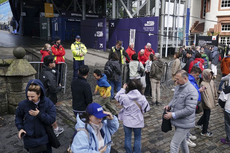 Visitantes del castillo de Edimburgo deambulan el sitio, el cual tuvo que cerrar sus puertas debido a los fuertes vientos por la tormenta Floris, en Escocia, el lunes 4 de agosto de 2025. (Jane Barlow/PA vía AP)