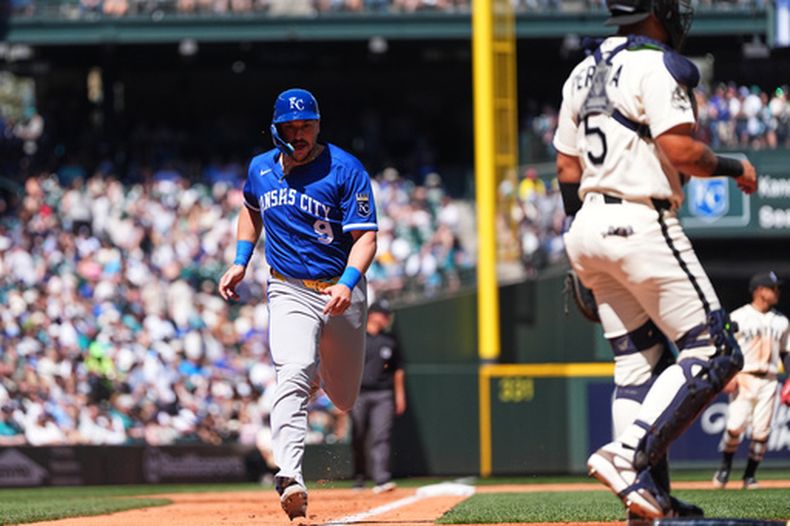 Vinnie Pasquantino, de los Reales de Kansas City, anota mientras Jac Caglianone conecta para un out forzado de Michael Massey en la segunda base, mientras el receptor de los Marineros de Seattle, Jhonny Pereda, observa durante la cuarta entrada de un partido de béisbol, el domingo 3 de mayo de 2026, en Seattle. (Foto AP/Lindsey Wasson).