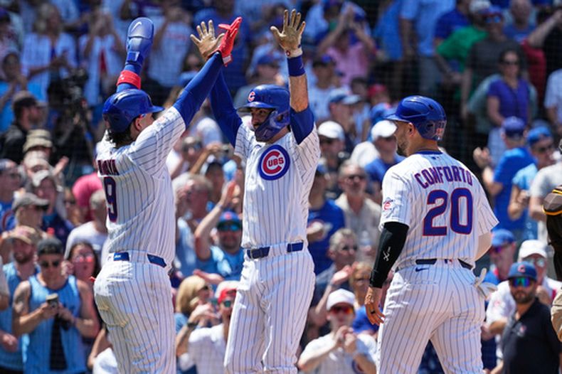 Dansby Swanson, centro, de los Cachorros de Chicago, celebra con Miguel Amaya, izquierda, y Michael Conforto después de batear un jonrón de tres cerreras durante la tercera entrada del juego de béisbol de Grandes Ligas contra los Padres de San Diego, el miércoles 1 de julio de 2026, en Chicago. (AP Foto/Nam Y. Huh)