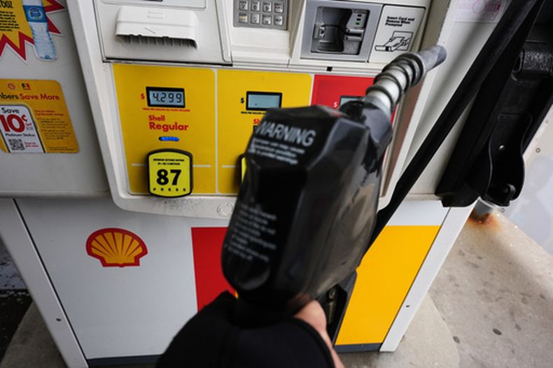 ARCHIVO - Una pantalla muestra el precio del combustible mientras un cliente sostiene una manguera antes de llenar el depósito de su vehículo en una gasolinera en Lincolnshire, Illinois, el 15 de abril de 2026. (AP Foto/Nam Y. Huh, archivo)