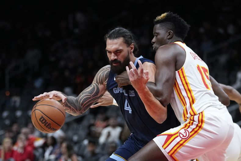El pívot de los Grizzlies de Memphis Steven Adams trabaja en el encuentro ante el pívot de los Hawks de Atlanta Clint Capela en el encuentro de pretemporada del 12 de octubre del 2023. (AP Foto/John Bazemore)