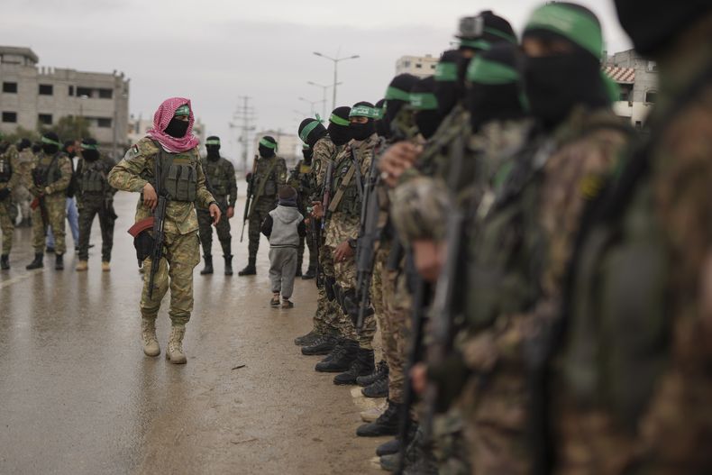 Combatientes de Hamás, en formación antes de la entrega de rehenes israelíes a la Cruz Roja en Nuserait, en la Franja de Gaza, el 22 de febrero de 2025. (AP Foto/Abdel Kareem Hana)