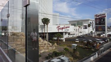 ARCHIVO - Una persona, reflejada en un vidrio, camina cerca del hotel-casino Tropicana de Las Vegas, el 16 de mayo de 2023. (AP Foto/John Locher, Archivo)