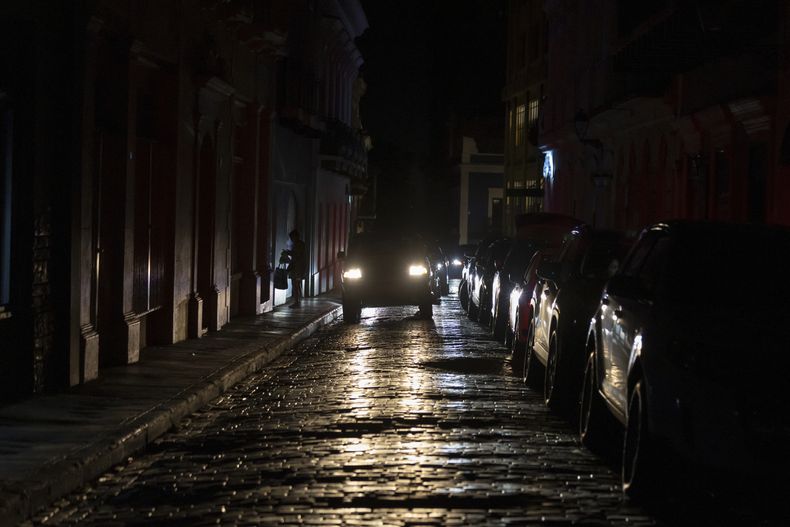 Los faros de un auto iluminan las calles empedradas del Viejo San Juan, Puerto Rico, durante un apagón en la isla, el 16 de abril de 2025. (AP Foto/Alejandro Granadillo)