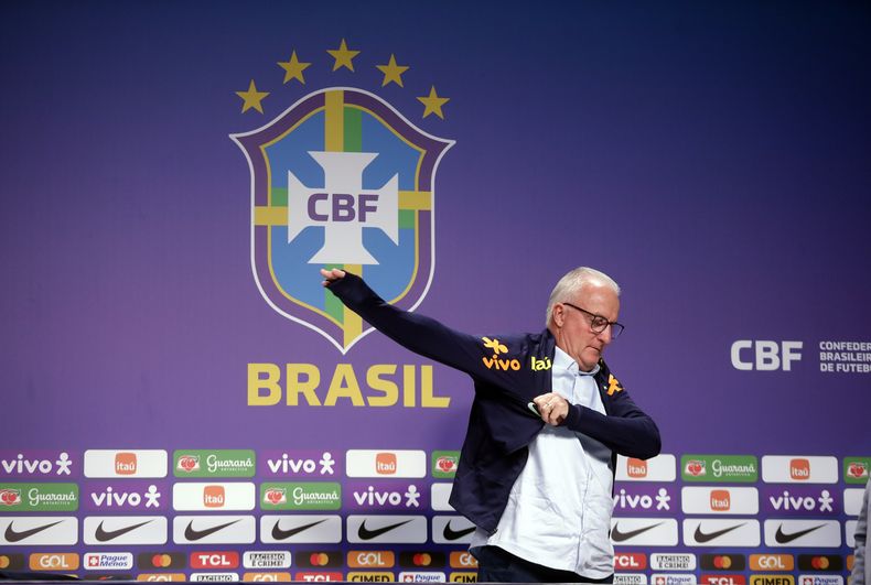 Dorival Junior, el nuevo técnico de la selección de Brasil, se coloca una chaqueta del equipo nacional durante una rueda de prensa en Río de Janeiro, el jueves 11 de enero de 2024. (AP Foto/Bruna Prado)