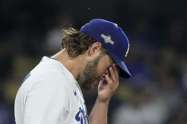 Clayton Kershaw, abridor de los Dodgers de Los Ángeles, se frota la cara después de que Alek Thomas, de los Diamondbacks de Arizona, anotara con un doble productor de Evan Longoria, durante la primera entrada del Juego 1 de la Serie Divisional de la Liga Nacional, el sábado 7 de octubre de 2023, en Los Ángeles. (AP Foto/Mark J. Terrill)