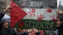Varias personas gritan consignas durante una protesta en Bucarest, Rumania, el sábado 4 de noviembre de 2023, en apoyo a los palestinos de la Franja de Gaza. (AP Foto/Vadim Ghirda)