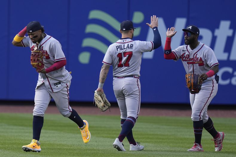 Desde la izquierda, los jardineros Ronald Acuña Jr., Kevin Pillar y Michael Harris II de los Bravos de Atlanta celebran tras la victoria ante los Mets de Nueva York en el primer juego de una doble cartelera, el lunes 1 de mayo de 2023, en Nueva York. (AP Foto/Seth Wenig)
