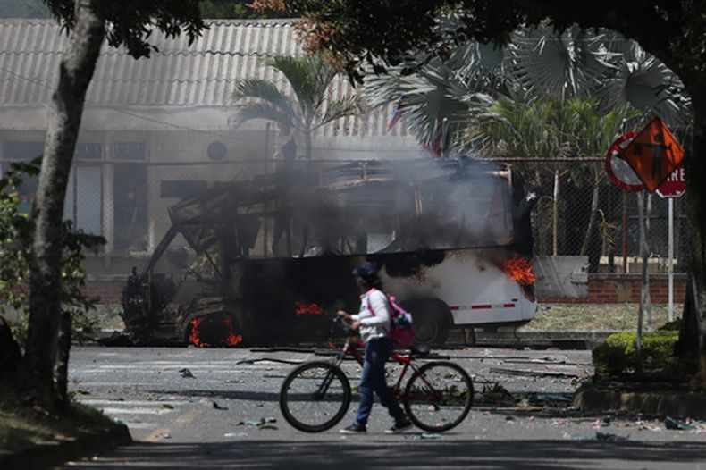 Un autobús arde tras una explosión en las afueras de una base militar en Cali, Colombia, el viernes 24 de abril de 2026. (Foto AP/Santiago Saldariaga)