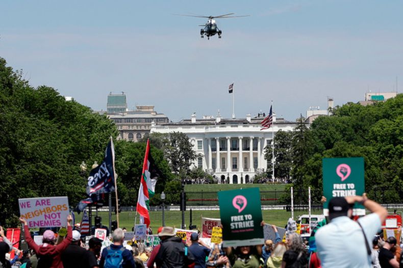 El helicóptero Marine One, con el presidente Donald Trump a bordo, despega del jardín sur de la Casa Blanca mientras manifestantes se concentran en el National Mall durante una protesta el 1 de mayo de 2026 en Washington. (Foto AP/Rahmat Gul)