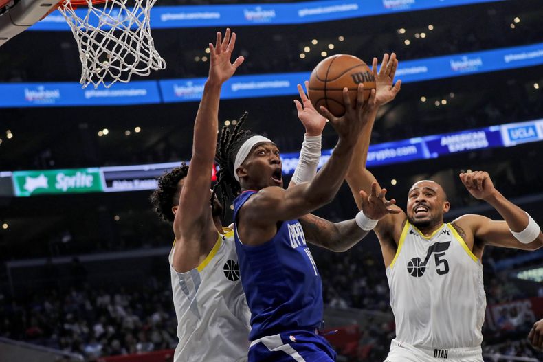 Terrance Mann, de los Clippers de Los Ángeles, encesta frente a Talen Horton-Tucker (5) y Keyonte George, del Jazz de Utah, el viernes 5 de abril de 2024 (AP Foto/Etienne Laurent)