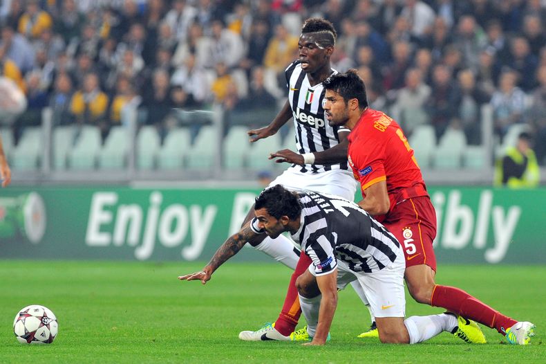 El jugador de la Juventus, Carlos Tevez, abajo, disputa un bal&oacute;n en un partido contra Galatasaray en la Liga de Campeones el mi&eacute;rcoles, 2 de octubre de 2013, en Tur&iacute;n, Italia. (AP Photo/Massimo Pinca)