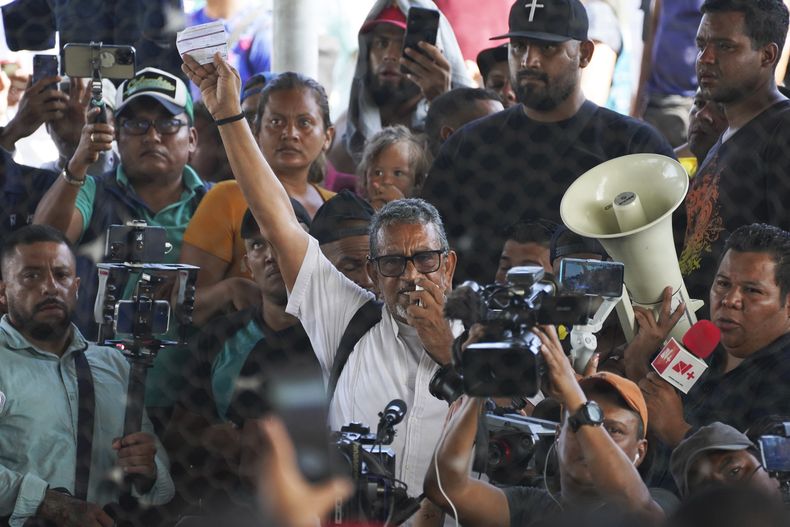 ARCHIVO - Luis García Villagrán, coordinador del Centro para la Dignificación Humana A.C., sostiene un formulario migratorio múltiple mientras conversa con un grupo de migrantes que se refugian en un complejo deportivo en Huixtla, Chiapas, México, el 8 de junio de 2022. (Foto AP/Marco Ugarte, Archivo)