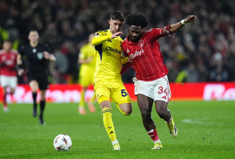 Alaettin Ekici, del Fenerbahce, y Ola Aina, del Nottingham Forest, disputan un balón durante el cotejo de vuelta de la Liga Europa disputado el jueves 26 de febrero de 2026 (Jacob King/PA via AP)
