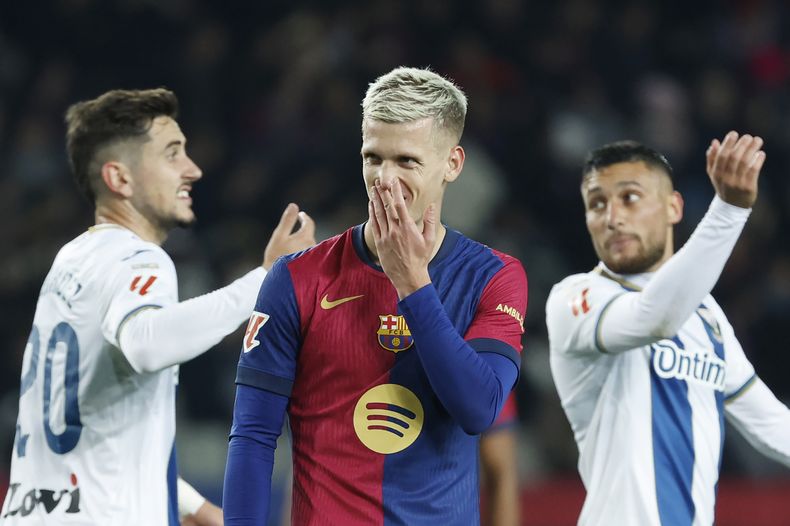 Dani Olmo, del Barcelona, se lleva una mano al rostro durante un partido ante Leganés, el domingo 15 de diciembre de 2024 (AP Foto/Joan Monfort)