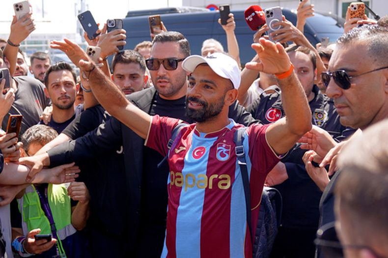 Mohamed Salah, de Egipto, saluda a fanáticos mientras porta la camiseta del Trabzonspor, su nuevo equipo, al llegar al aeropuerto de Estambul, el miércoles 5 de agosto de 2026, en Estambul, Tuquía. (Samet Yalcin/DIA Photo via AP)