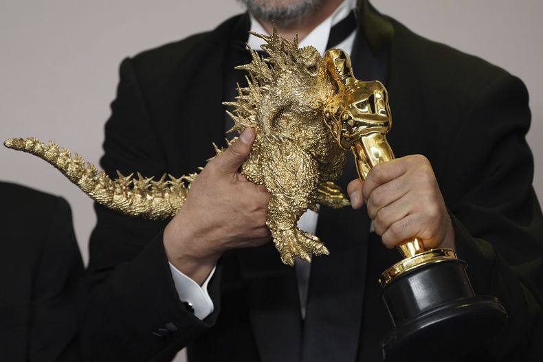 Takashi Yamazaki posa con un muñeco de Godzilla y el premio a mejores efectos visuales por Godzilla Minus One en los Oscar el domingo 10 de marzo de 2024, en el Teatro Dolby en Los Angeles. (Foto Jordan Strauss/Invision/AP)