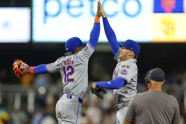 El campocorto de los Mets de Nueva York, Francisco Lindor, a la izquierda, celebra con el jardinero izquierdo Brandon Nimmo, segundo desde la izquierda, después del último out en la novena entrada contra los Padres de San Diego, el sábado 24 de agosto de 2024, en San Diego. (AP Foto/Brandon Sloter)