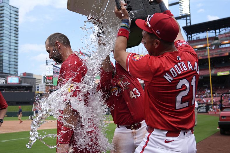 Paul Goldschmidt de los Cardenales de San Luis felicitado por sus compañeros Pedro Pagés y Lars Nootbaar tras su jonrón de la victoria ante los Nacionales de Washington el domingo 28 de julio del 2024. (AP Foto/Jeff Roberson)