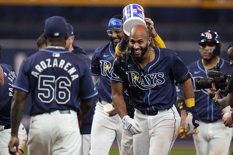 El dominicano Amed Rosario (derecha), de los Rays de Tampa Bay, festeja tras conectar el hit decisivo ante los Angelinos de Los Ángeles, el martes 16 de abril de 2024 (AP Foto/Chris OMeara)