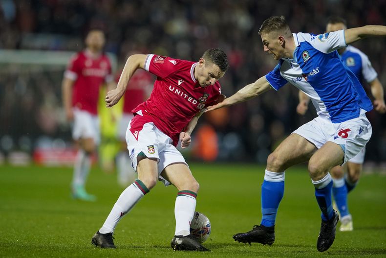Scott Wharton (derecha), del Blackburn, disputa una pelota con Paul Mullin, del Wrexham, en un duelo de la Copa de la FA, el lunes 29 de enero de 2024 (AP Foto/Dave Thompson)