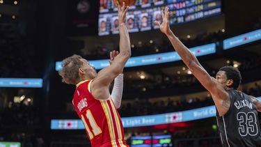 Trae Young (11), de los Hawks de Atlanta, lanza un tiro sobre la marca defensiva de Nic Claxton (33), de los Nets de Brooklyn, durante la segunda mitad del juego de baloncesto de la NBA, el miércoles 22 de noviembre de 2023, en Atlanta. (AP Foto/Hakim Wright Sr.)