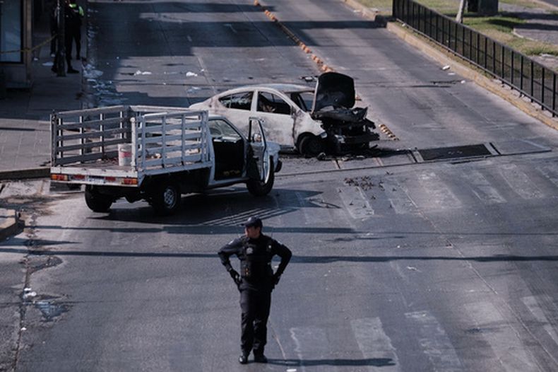 Un policía observa un vehículo calcinado que fue incendiado en una carretera de Guadalajara, Jalisco, México, el domingo 22 de febrero de 2026, tras la muerte del líder del Cártel Jalisco Nueva Generación, Nemesio Rubén Oseguera Cervantes, conocido como El Mencho. (Foto AP/Alejandra Leyva)