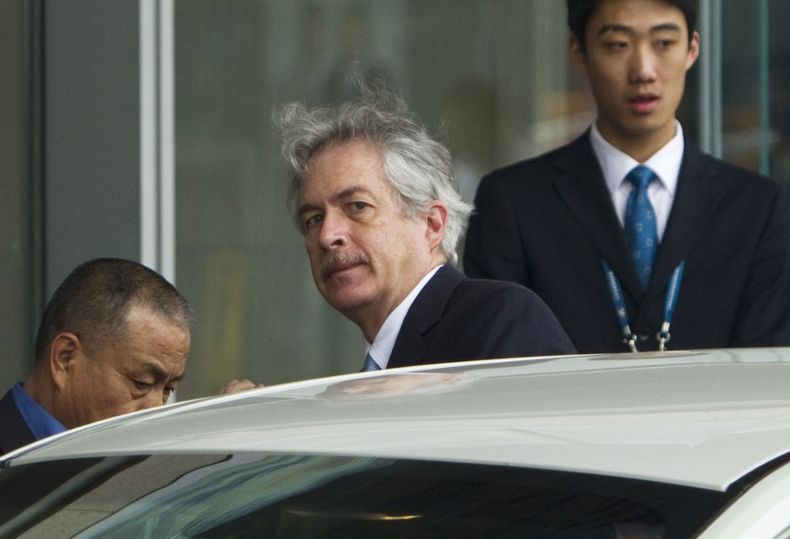 ARCHIVO - El director de la CIA, William Burns, centro, sube a un auto al arribar al Aeropuerto Internacional de la Capital, Beijing, 1 de mayo de 2012. (AP Foto/Alexander F. Yuan, File)