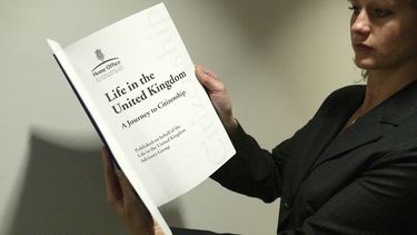 ARCHIVO – Una mujer sostiene una copia del libro “La vida en el Reino Unido”, que sirve como ayuda para aprobar el examen para obtener la ciudadanía británica, en el Museo Británico en el centro de Londres, el 31 de octubre de 2005. (AP Foto/Sergio Dionisio, Archivo)