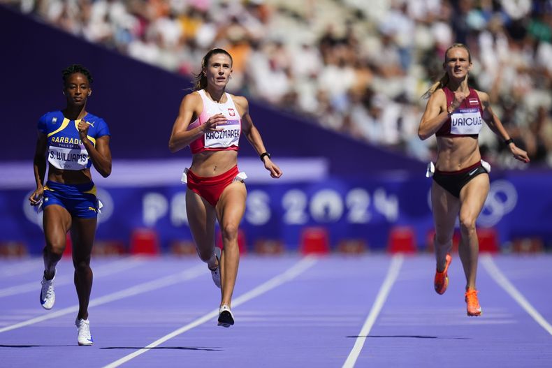 Velocistas compiten en una de las series clasificatorias de los 400 metros en los Juegos Olímpicos de París en el Stade de France el lunes 5 de agosto de 2024, en Saint-Denis, Francia. (AP Foto/Petr David Josek)