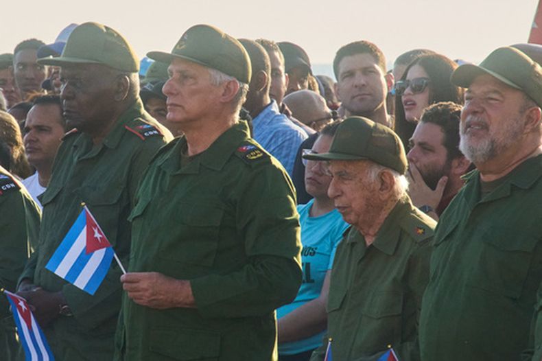 El presidente de Cuba, Miguel Díaz-Canel (segundo desde la izquierda), y el nieto de Raúl Castro, Raúl Guillermo Rodríguez Castro, en el centro al fondo, participan en una manifestación en apoyo al expresidente Raúl Castro frente a la embajada de Estados Unidos en La Habana, Cuba, el viernes 22 de mayo de 2026. (AP Foto/Ramón Espinosa)